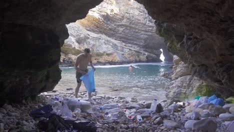 environmental pollution.man collecting garbage thrown into nature.