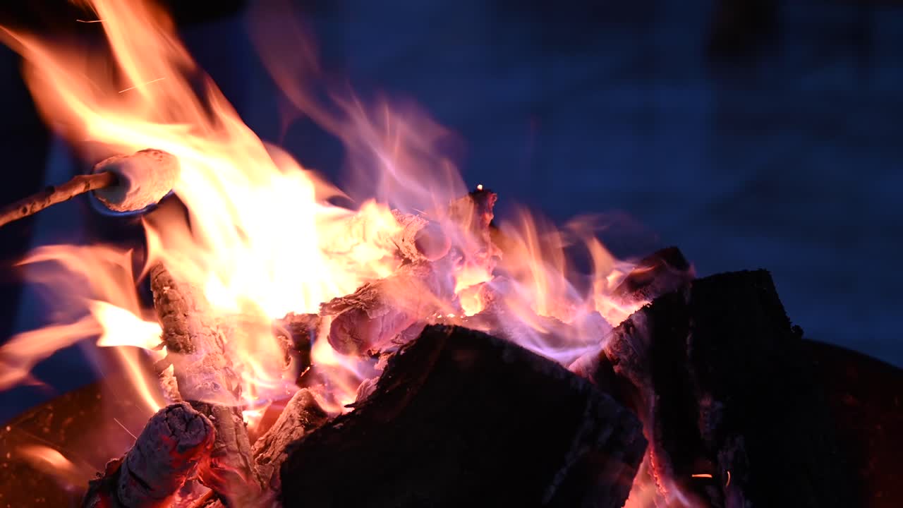 Close up of marshmallows warming up on a burning fireplace