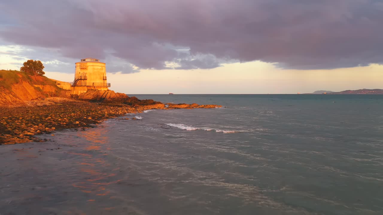 antena de vuelo bajo, puesta de sol de verano a lo largo de la costa con hermosos colores