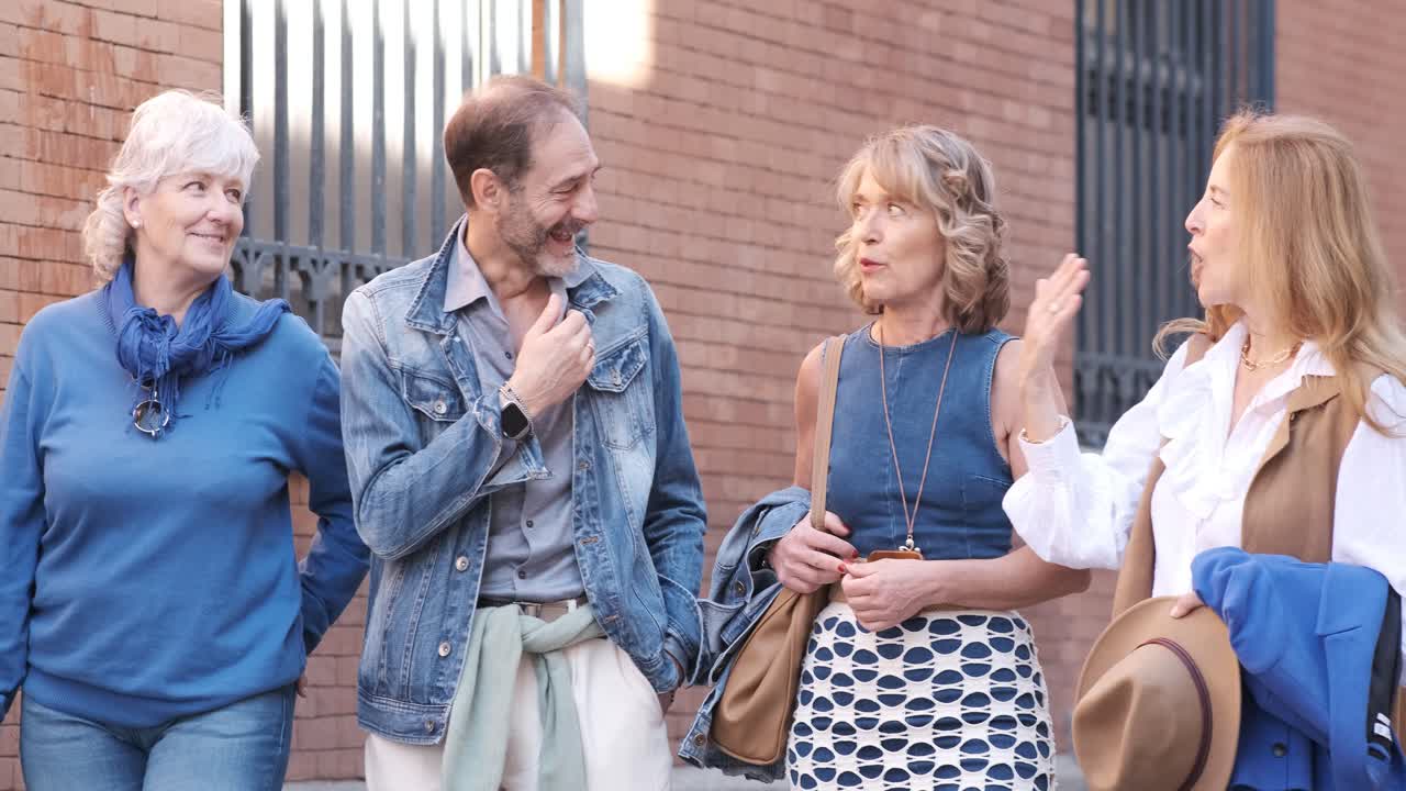 Company of middle aged friends walking on street