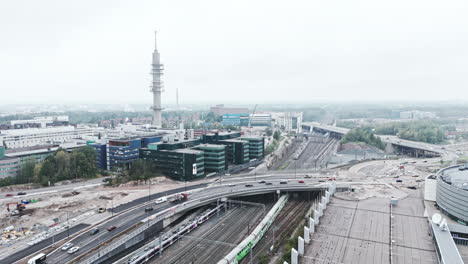 Wide-aerial-shot-approaching-a-bleak-industrial-concrete-television-and-radio-link-tower-in-Pasila,-Helsinki,-Finland-on-a-bright-and-foggy-day