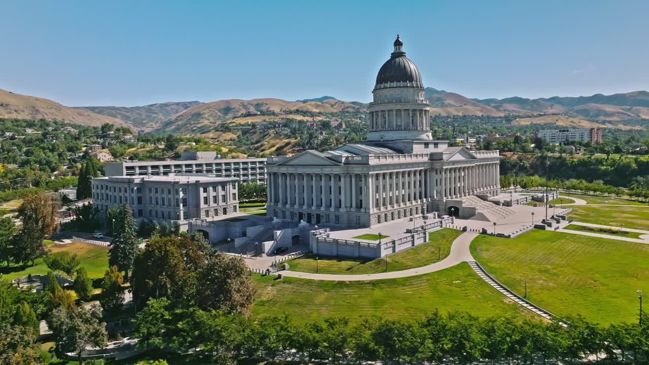 State capitol building with american flag waving, towards hillside residential