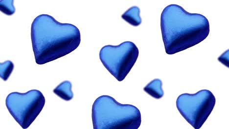 a stream of many different diameters heart shape wrapped colorfulchocolate candy flying on a white color background.romantic template love concept for mother's, st. valentine's and women's