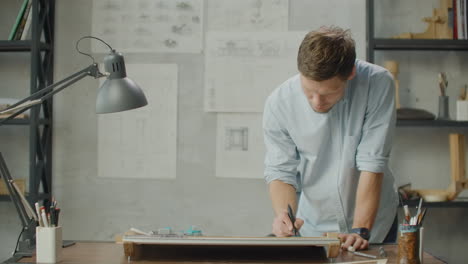 a male architect creates a drawing of a building on paper. to study the design of premises to create furniture and houses. large modern office draw on blackboard.