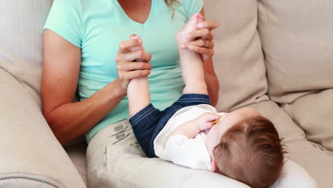 madre jugando con su bebé en el sofá