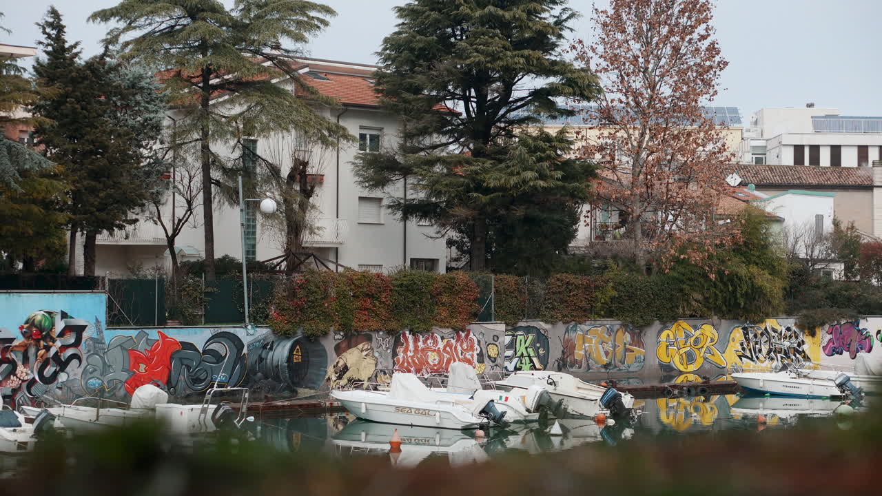 이탈리아 의 한 도시 에서 그라피티 와 배 들 이 있는 운하 장면