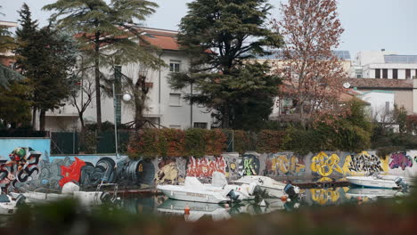 escena del canal con graffiti y barcos en una ciudad italiana