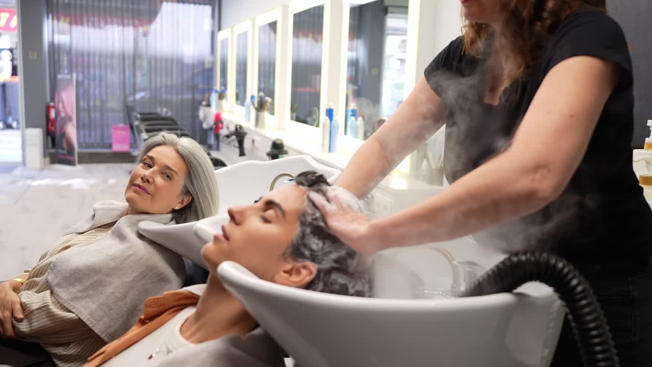 Hairdresser Washing Young Man's Hair in a Modern Salon