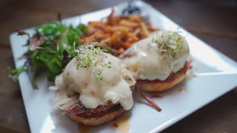 Eggs-Benedict-breakfast,-fries-and-salad