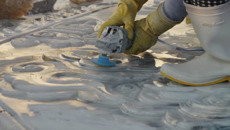 hands of sculptor in workwear carving and detailing white marble stone using hand tool, da nang city, vietnam