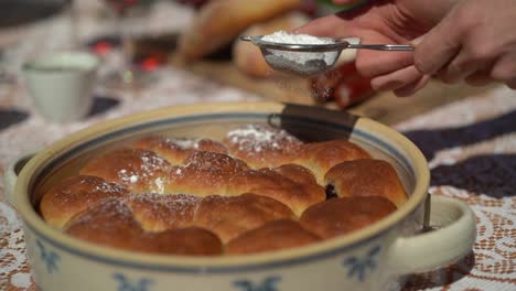 Zucker-Bestreut-Hausgemachte-Kuchen-In-Einem-Dekorierten-Topf-Draußen,-Sonnig,-Zeitlupe