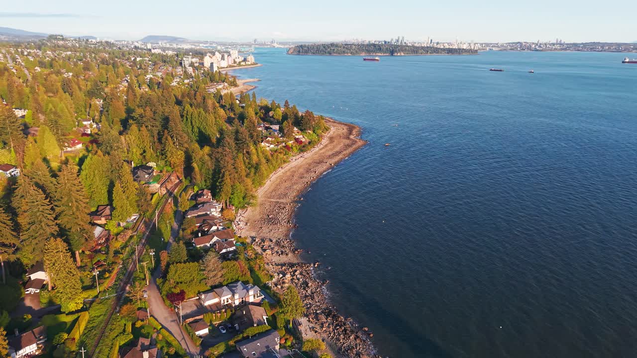 A scenic drone shot of the coast of Proctor Ave in West Vancouver with a view of Dundarave and Vancouver City on the horizon