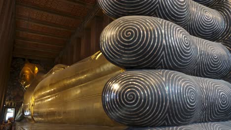 slow motion revealing shot of the golden wat pho buddha statue in bangkok