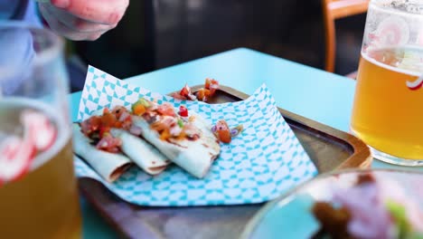 hand picking up taco next to beer