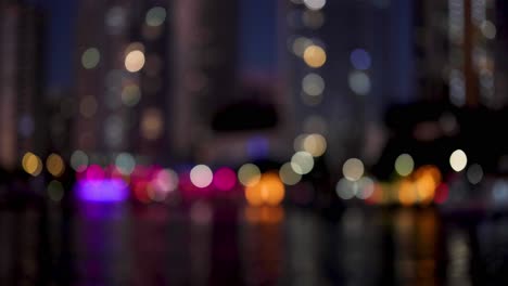 las coloridas luces de la ciudad que se reflejan en el agua por la noche