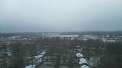 an aerial shot of homes in the country in the middle of winter with a thick heavy fog