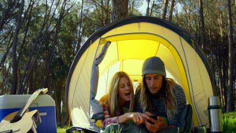 Pareja-Joven-Discutiendo-Por-Teléfono-Móvil-En-Tienda-De-Campaña-4k