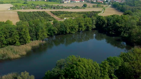 Vista-Aérea-De-Un-Pequeño-Lago-Entre-Campos-En-El-Bosque