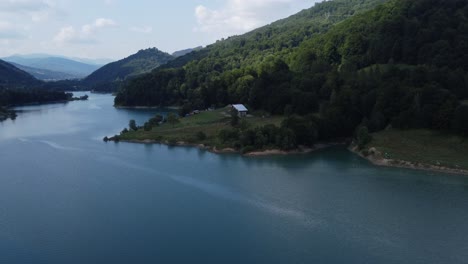 toma de órbita aérea de un hermoso y limpio ecosistema de lagos y bosques al atardecer en un día nublado en paltinu del valle de doftana en rumania