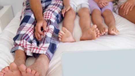 Family-using-laptop-on-bed