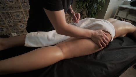 masaje anticelulítico en el salón de spa. el masajista masajea las nalgas, los muslos y las piernas. tratamiento relajante. adelgazamiento y formación del cuerpo. cuerpo y piel sanos. cuidado de amor propio