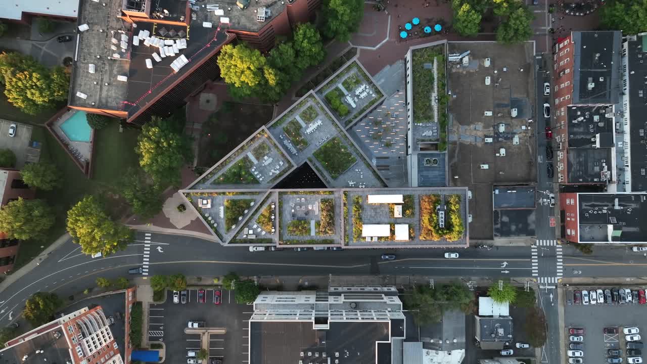 Outdoor living space. Green rooftop garden in urban city. Carbon emissions, climate change ESG theme. High drone shot. Top down aerial shot.