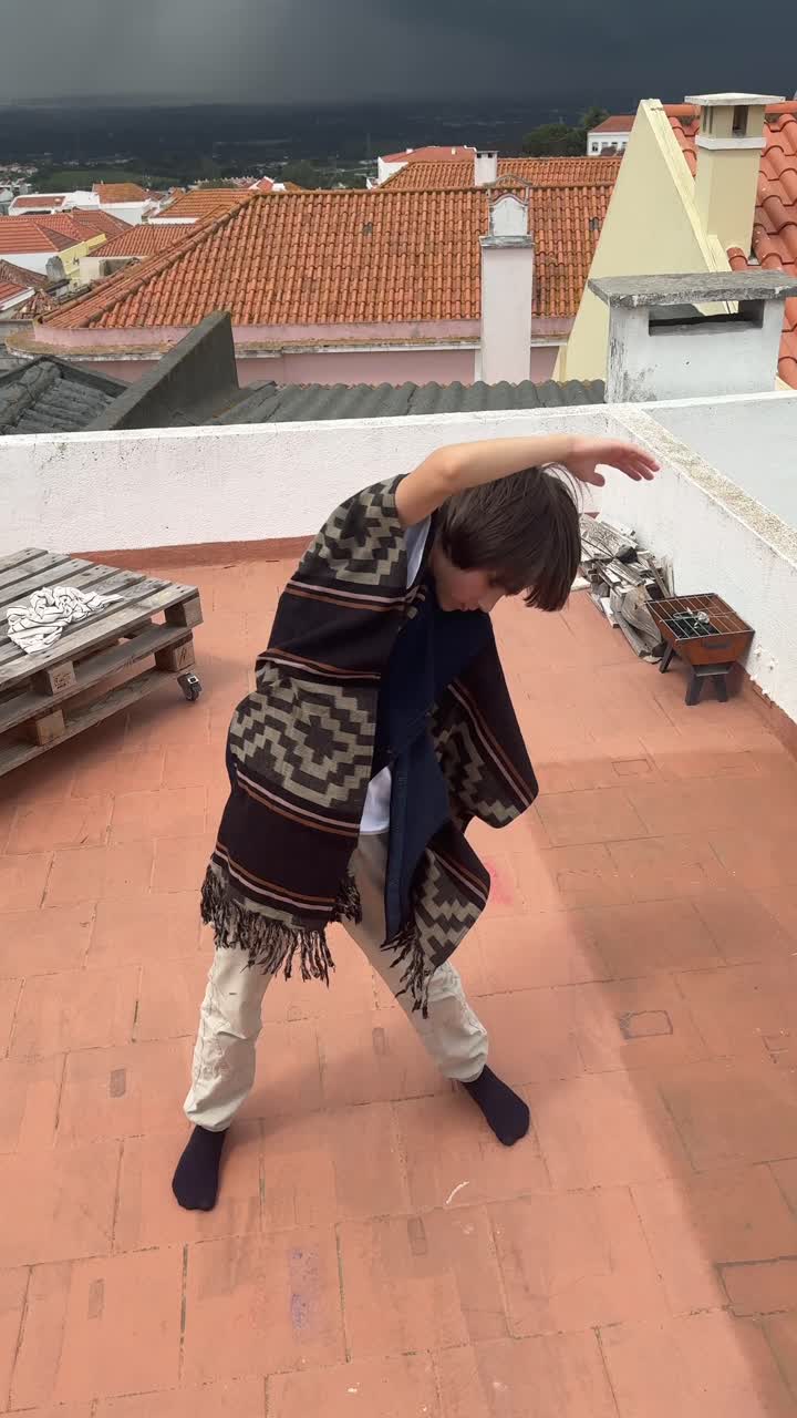 Bambino che fa yoga su un tetto con vista sulla città