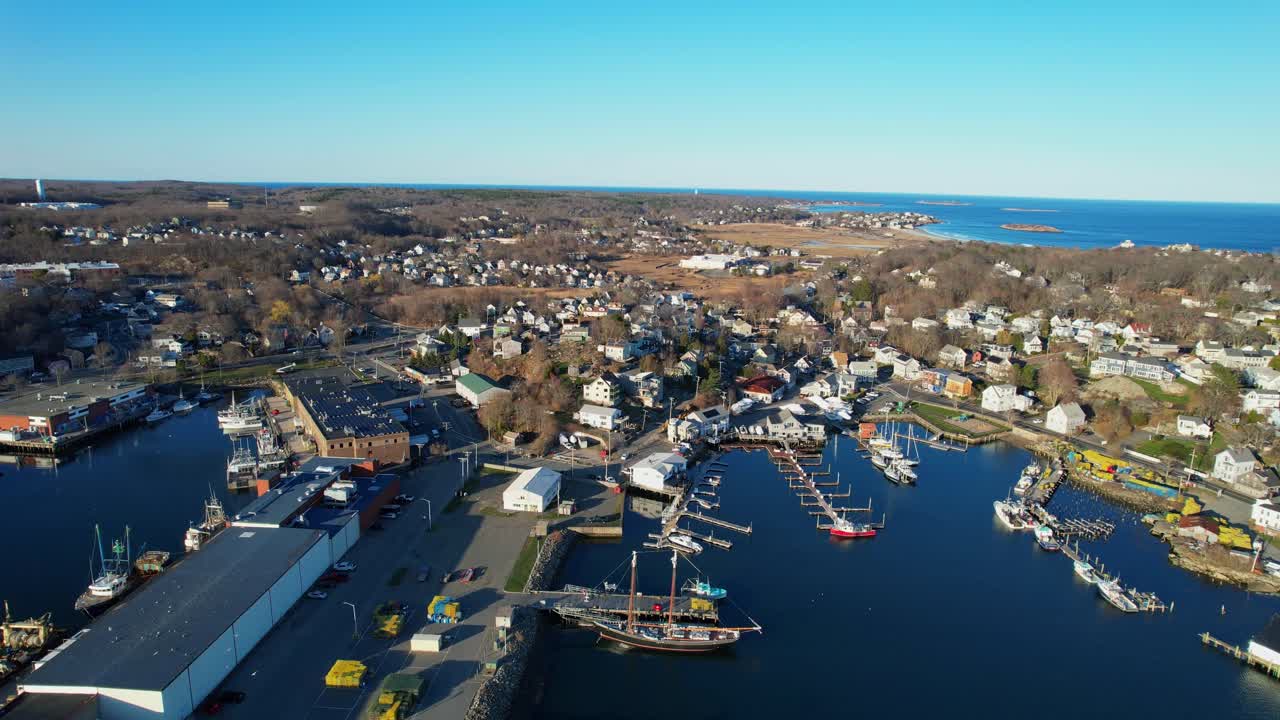 Volo in avanti di un drone sopra il molo peschereccio statale Jodrey al porto turistico di Inner Harbor, pieno di barche ancorate, Gloucester, Massachusetts, USA