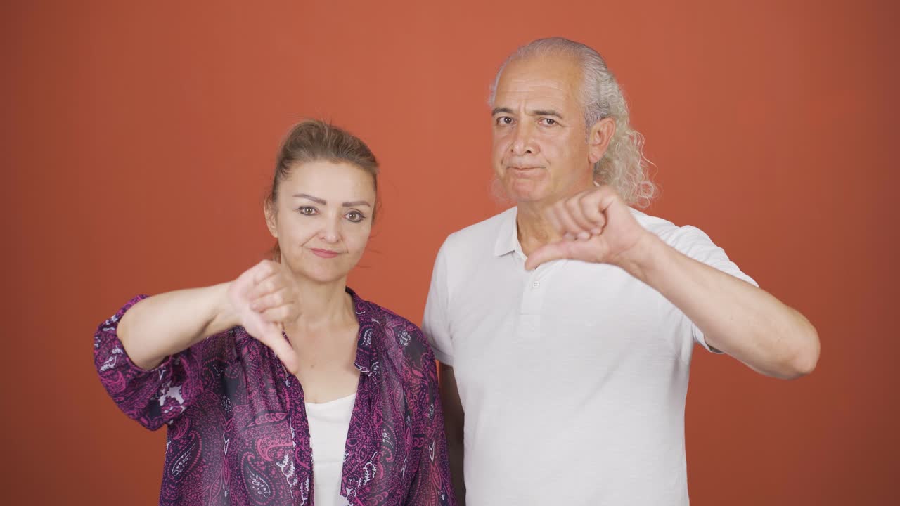 una pareja haciendo un gesto negativo a la cámara.