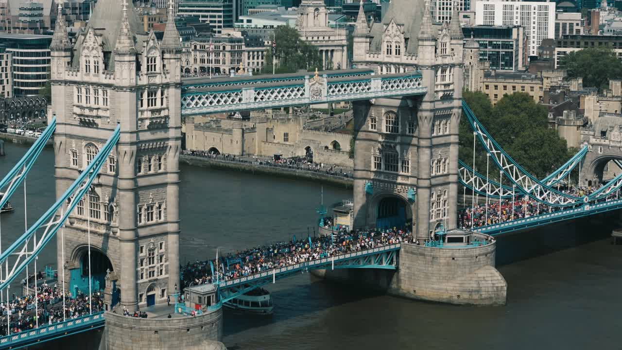 High diagonal aerial across Tower Bridge as marathon runners cross below