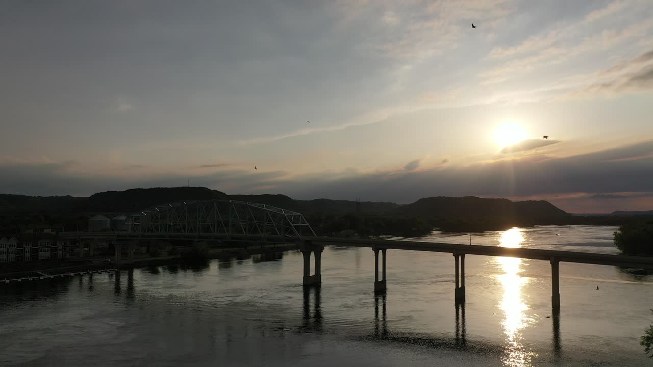 다리와 함께 강을 가로질러 해가 지는 모습