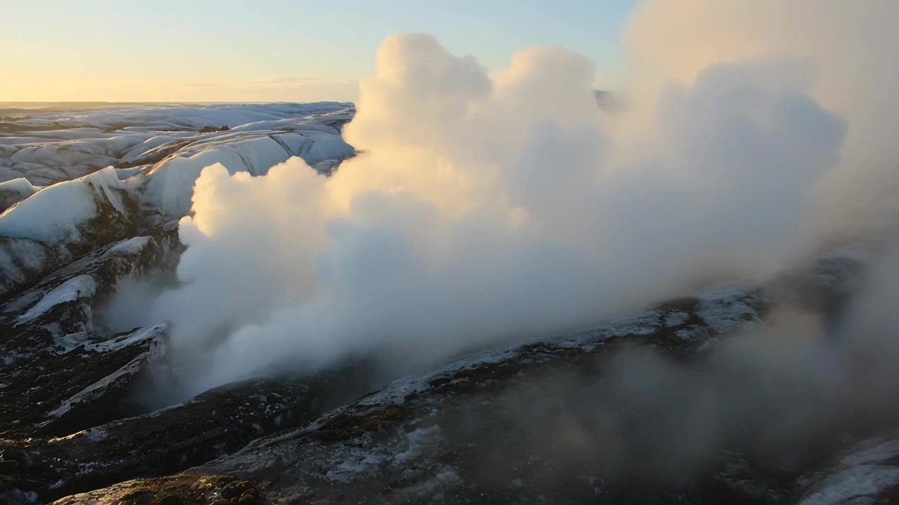 En tät vit ångplym stiger från en låg spricka längs glaciärkanten, solljus lyser upp isen.