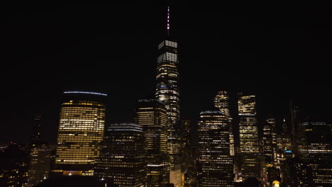 aerial view around night lit high-rise in manhattan, new york - orbit, drone shot