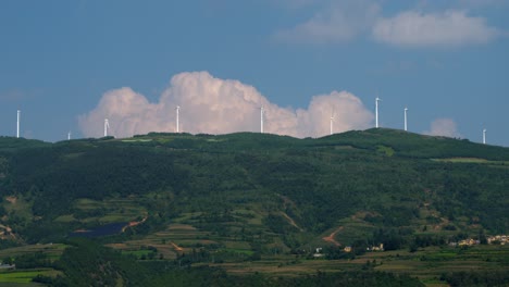 drone footage of large electric windmill on top of a hill