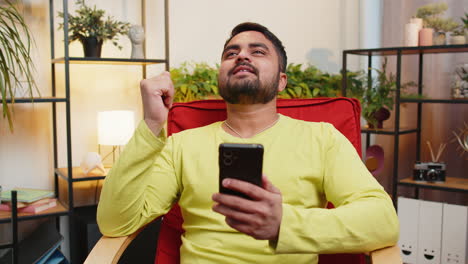 Sad indian man use smartphone surprised by bad news fortune loss fail lottery results deadline