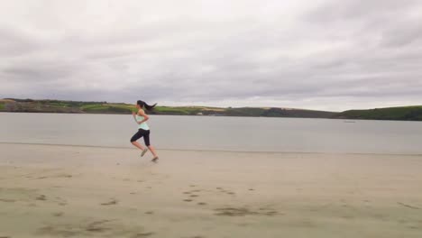 Mujer-En-Forma-Corriendo-Sobre-La-Arena