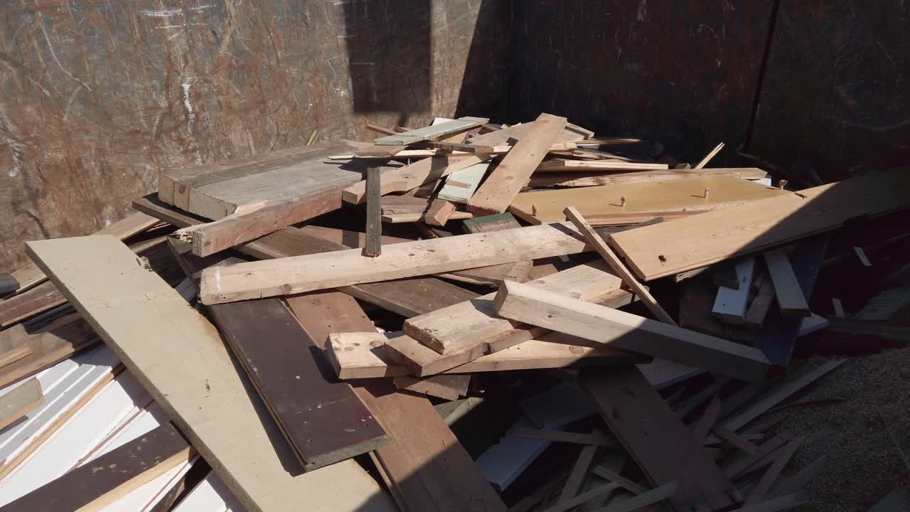 Old wooden boards falling into container, slow motion