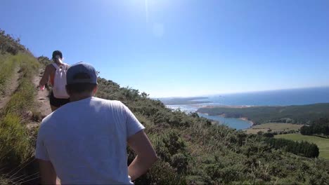 Wanderer-Klettern-Auf-Die-Spitze-Eines-Berges-Mit-Blick-Auf-Das-Meer-In-Kantabrien,-Spanien