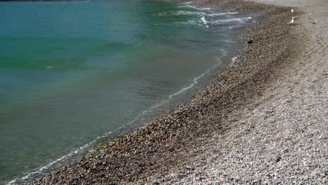 Primer-Plano-De-Suaves-Olas-Rompiendo-En-Una-Tranquila-Playa-De-Guijarros-En-Collioure-En-Un-Día-Ventoso