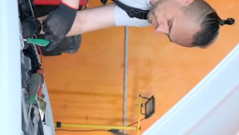 man working on an engine with a screwdriver in a workshop