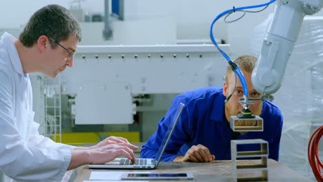 los ingenieros robóticos examinan la máquina robótica en el almacén 4k