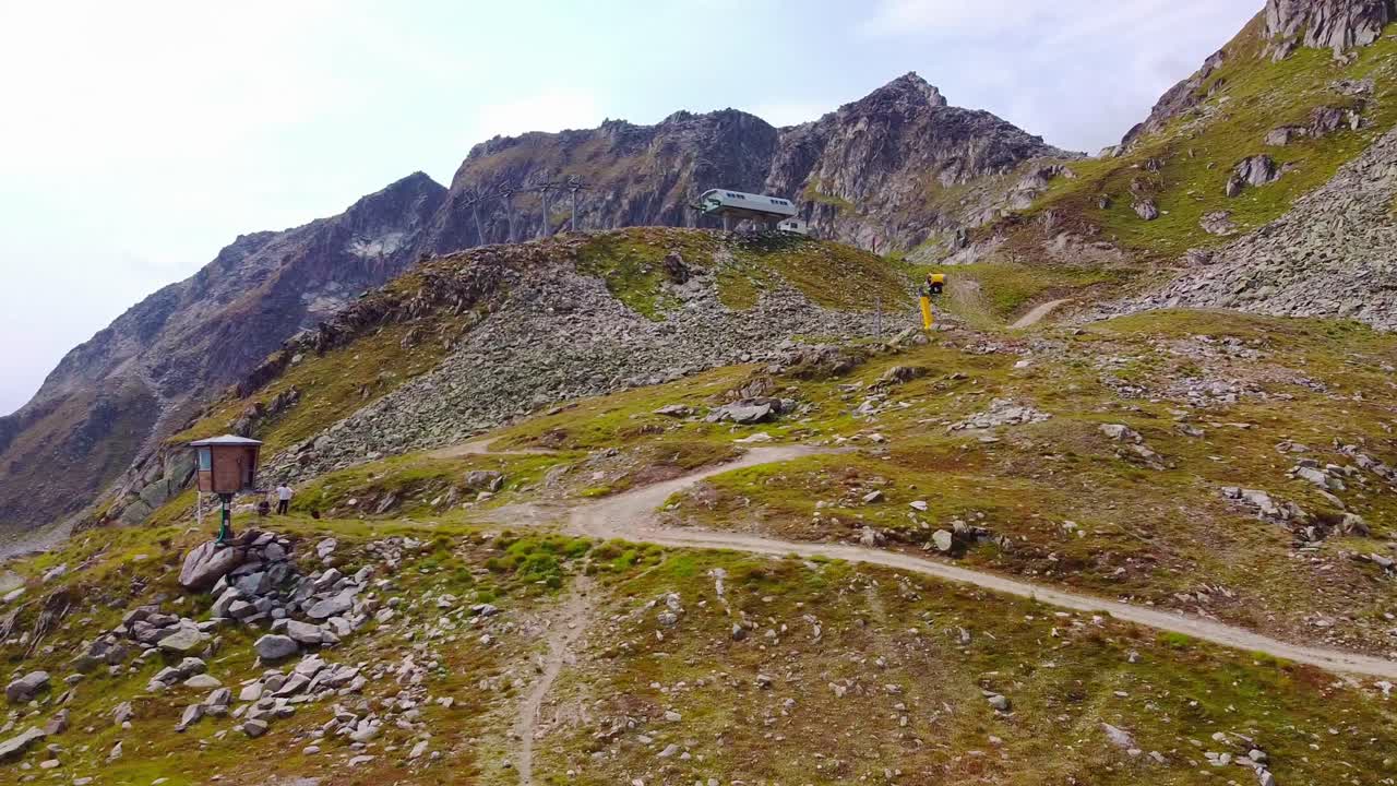 Hiking trail in the swiss alps aerial view, scenic mountain landscape with a watchtower in rocky terrain