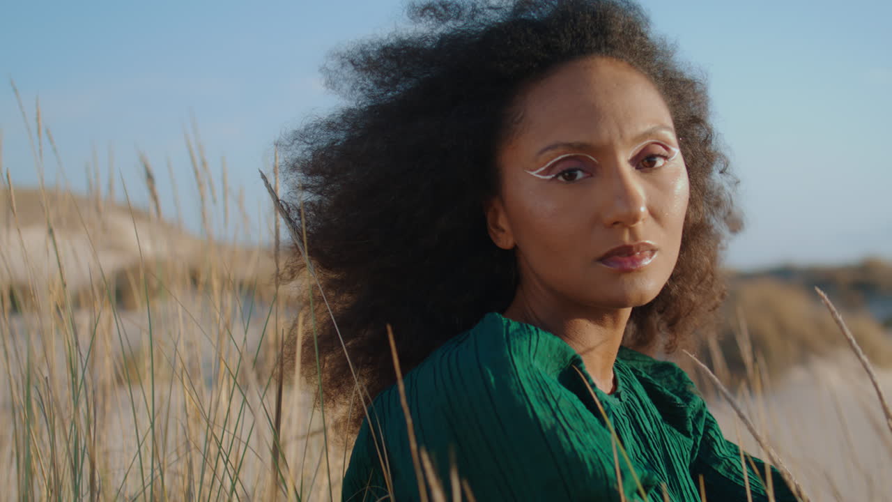 모래에 앉아있는 여성의 초상화 카메라. 풍경을 즐기는 꿈꾸는 소녀.