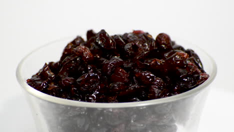 Transparent-glass-bowl-with-dehydrated-cranberry-rotating-on-a-white-background