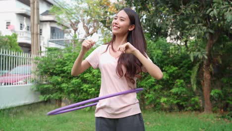 woman exercising with a hula hoop in a garden