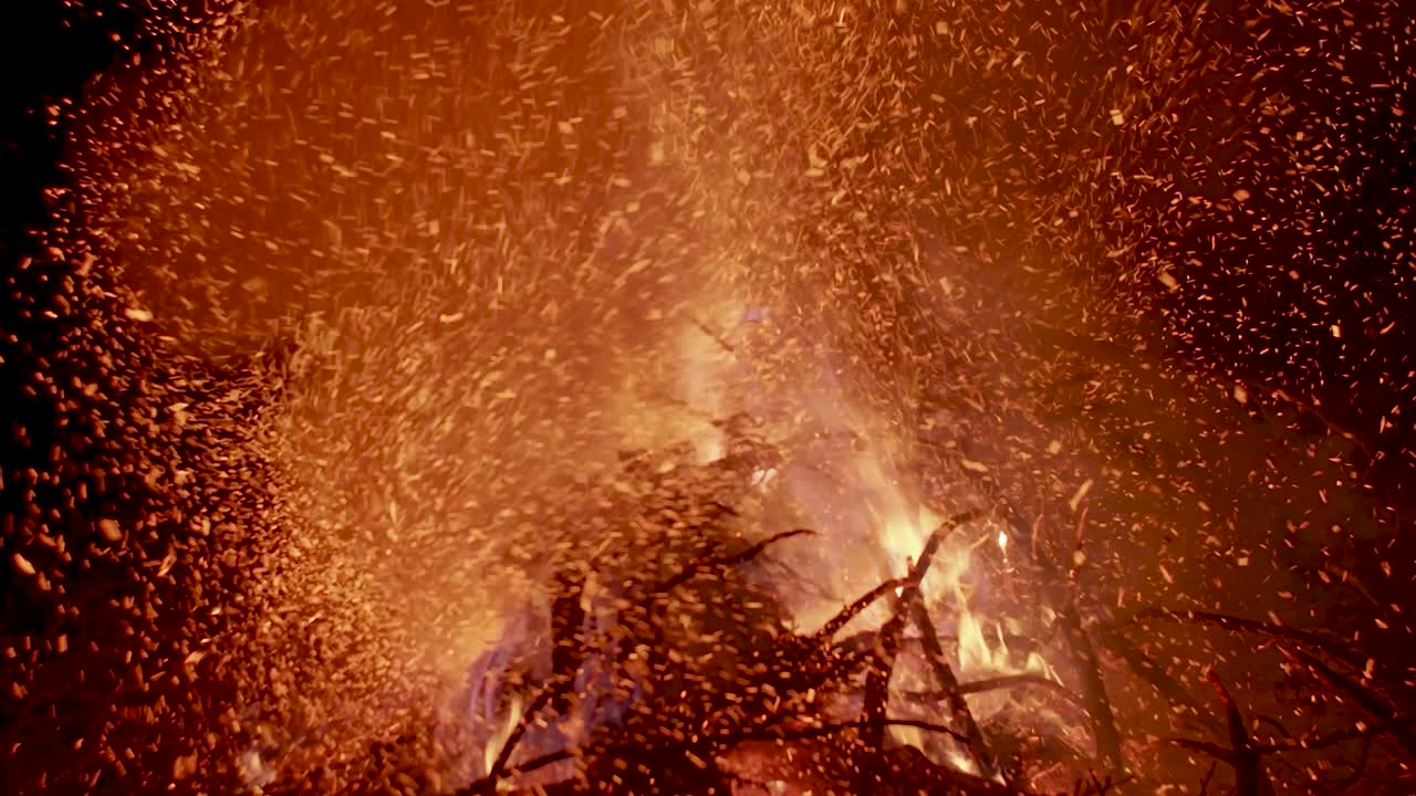 어두운 밤하늘에 빛나는 모닥불 불씨를 날리는 뜨거운 불길