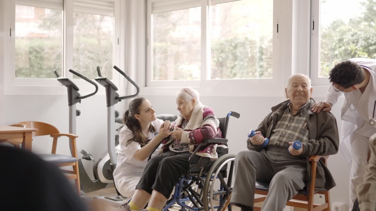 Physiotherapists talking to senior people while exercising in geriatrics