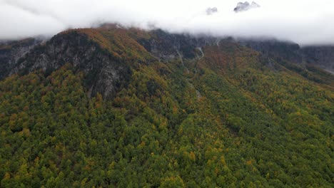 Beautiful-mountain-with-colorful-forest-and-high-peaks-under-misty-fog-at-Autumn