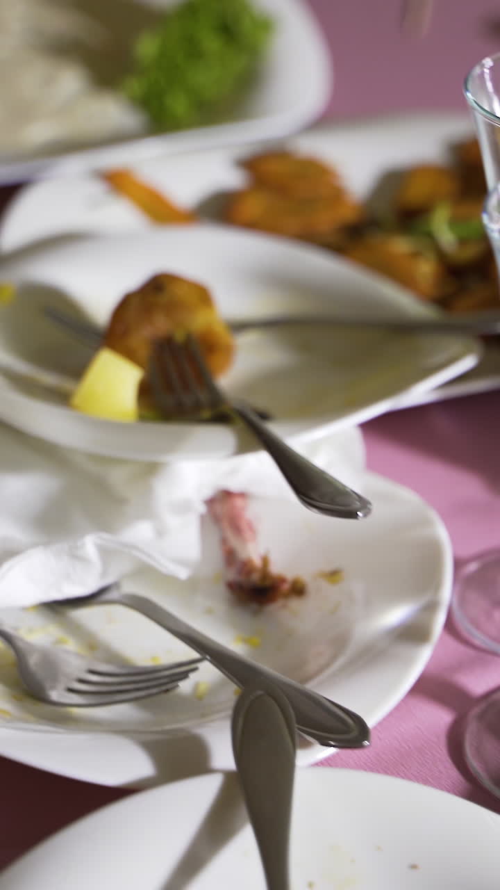 Dirty dishes on a table in a restaurant. After eating Vertical video
