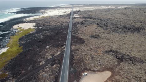 Vista-Aérea-De-Carreteras-Rectas-Y-Coches-En-Movimiento-En-La-Costa-Volcánica